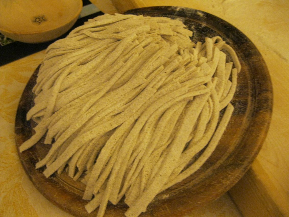 Pizzoccheri fatti in casa su tagliere. Pasta fresca tipica valtellinese, pronta per la cottura. Ricetta tradizionale.