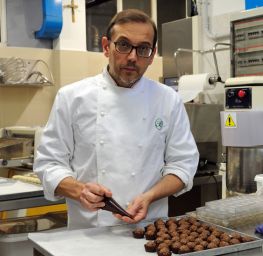 Chef pasticcere italiano decora cioccolatini. Pasticceria artigianale, dolci fatti in casa.