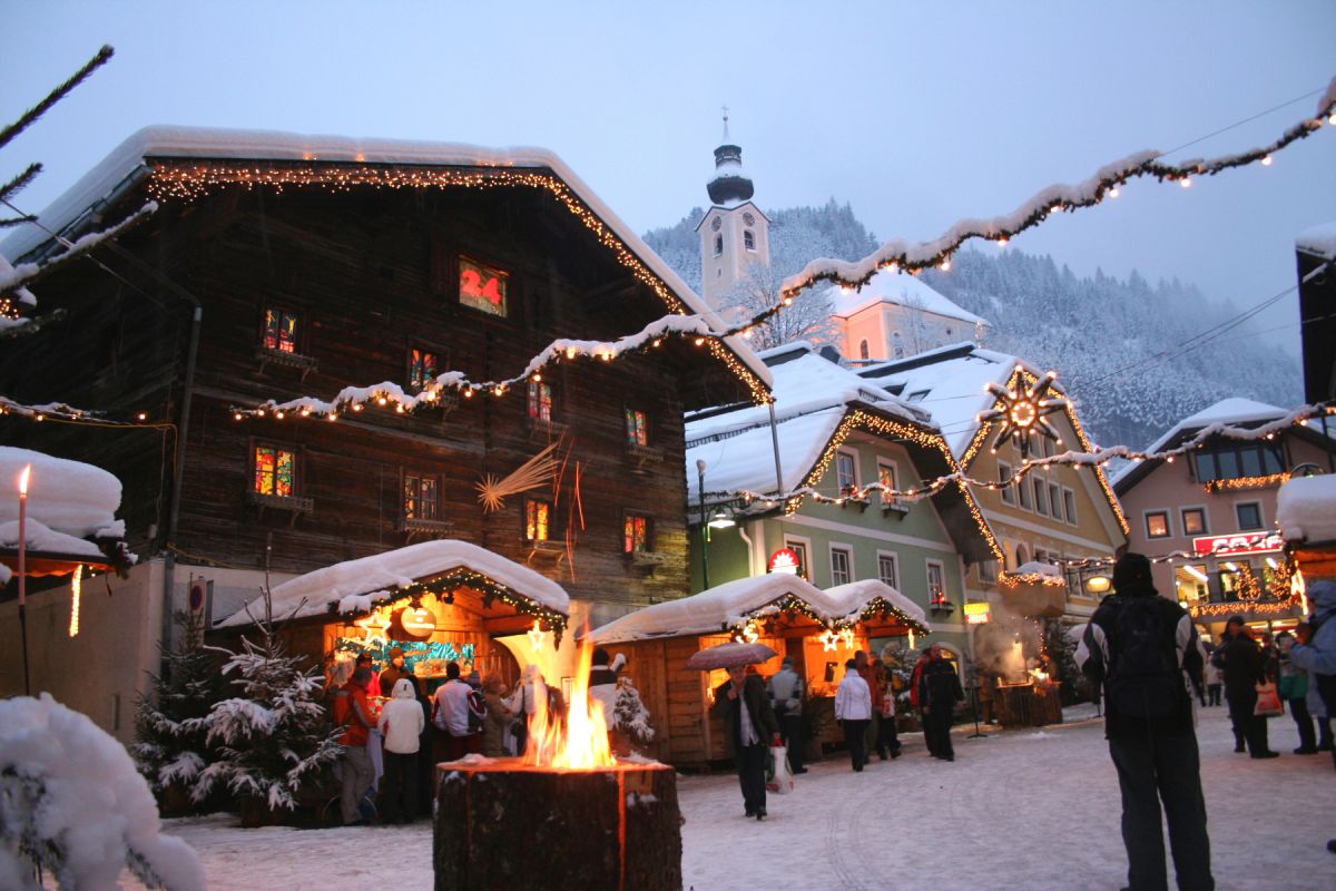 Mercatino di Natale alpino a Grossarl, Austria. Chalet innevati e luci festive. Atmosfera natalizia.