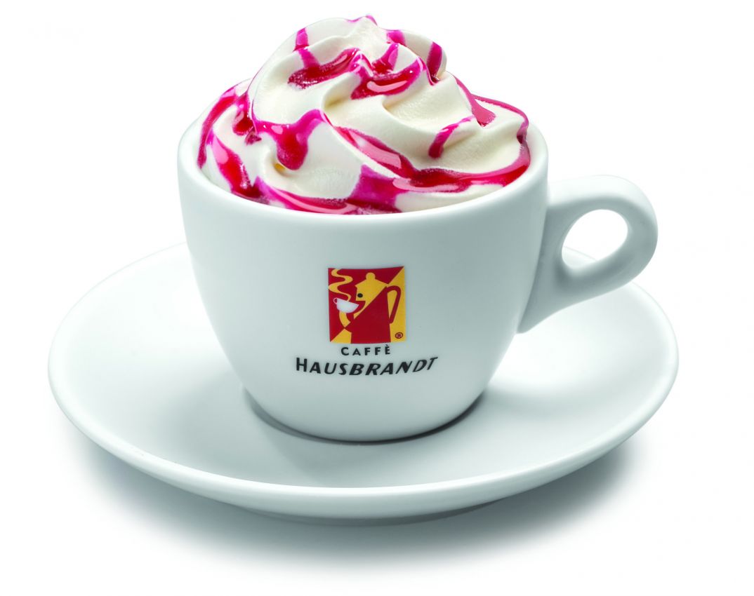 Cioccolata calda Hausbrandt con panna e amarena. Bevanda golosa in tazza bianca.