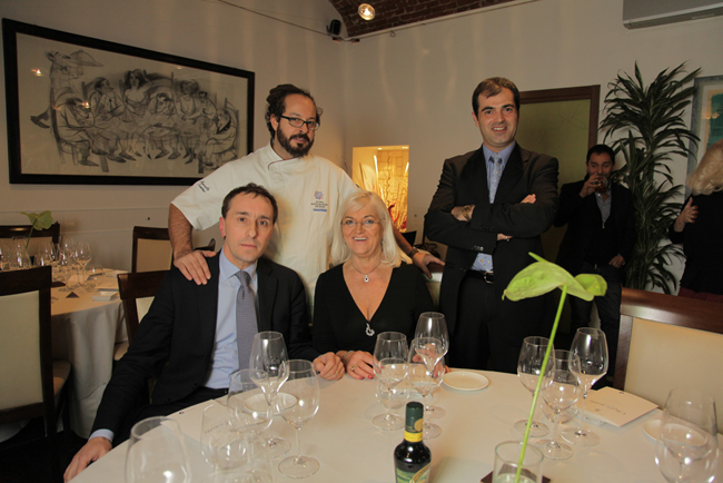 Serata a Torino: chef e ospiti a cena in ristorante elegante. Tavola imbandita e atmosfera conviviale.