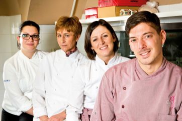 Team di chef sorridenti in cucina. Ristorante, gastronomia, professionisti del cibo, alta cucina.