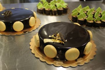Torte al cioccolato lucide con macarons. Dolci artigianali, pasticceria italiana.