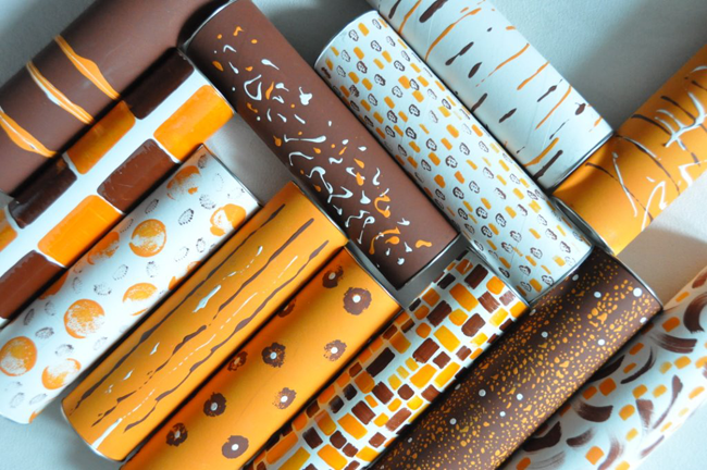 Cilindri decorativi marroni e arancioni. Motivi geometrici e astratti. Design creativo.