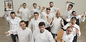 Team di chef in divisa bianca con utensili da cucina. Ristorante di alta cucina.