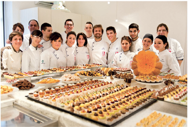 Team di pasticceri Montersino con dolci assortiti. Corso di pasticceria, alta cucina.