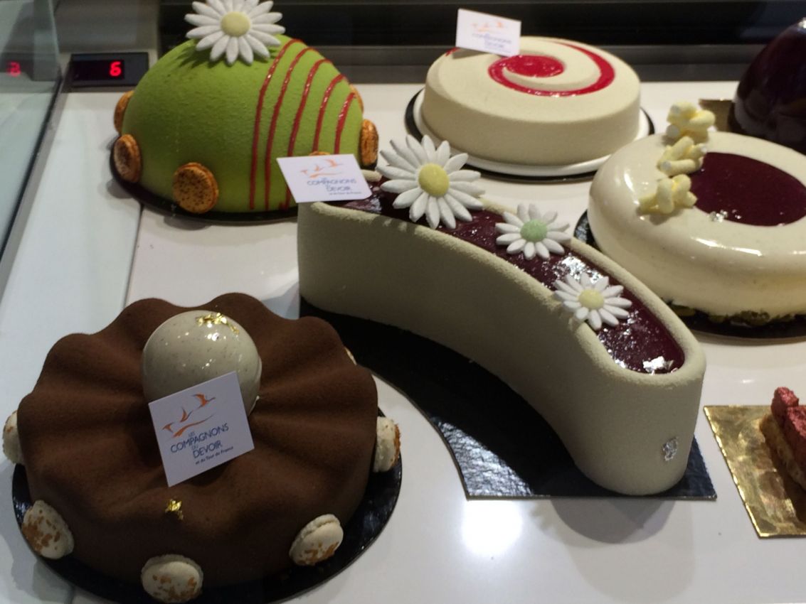 Dolci di Parigi in vetrina: torte decorate con fiori, cioccolato e frutta. Pasticceria francese di alta qualità.