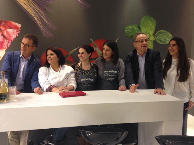 Fratelli Grassi con blogger a evento culinario. Gruppo di persone sorridenti dietro un bancone bianco. Cucina, food blogger.