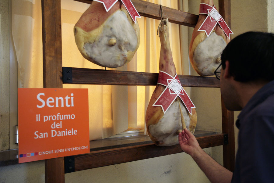 Degustazione prosciutto San Daniele. Uomo assaggia prosciutto DOP. Salumi tipici italiani, eccellenza gastronomica.