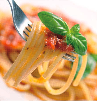 Pasta al pomodoro su forchetta con basilico. Cucina italiana.