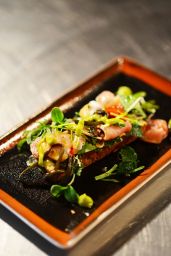 Focaccia gourmet con prosciutto, verdure fresche e salsa. Piatto invitante su vassoio elegante. #focaccia #gourmet #cucinaitaliana