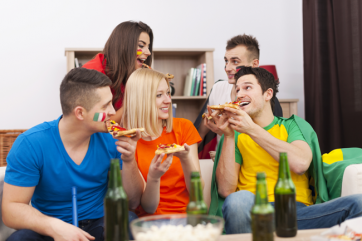 Amici tifosi a casa con pizza e birra. Ricette e cibo per Mondiali calcio.