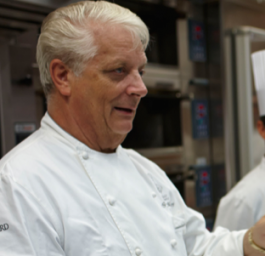 Chef pasticcere in divisa bianca. Esperto di dolci, cucina e pasticceria.