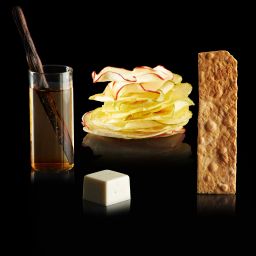 Strudel di mele gourmet: chips di mela, salsa alla vaniglia, croccante. Dessert elegante su fondo nero.