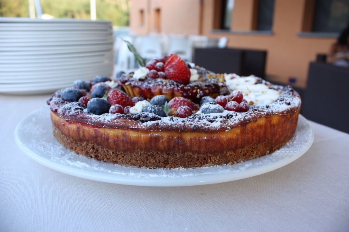 Tortino di ricotta al miele con frutti di bosco. Dessert goloso con biscotto e confettura.