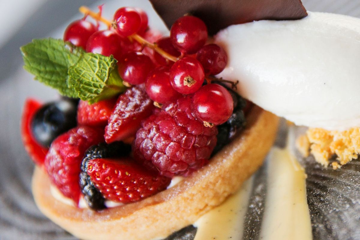 Crostata ai frutti di bosco con gelato. Dessert delizioso con fragole, lamponi e mirtilli freschi.