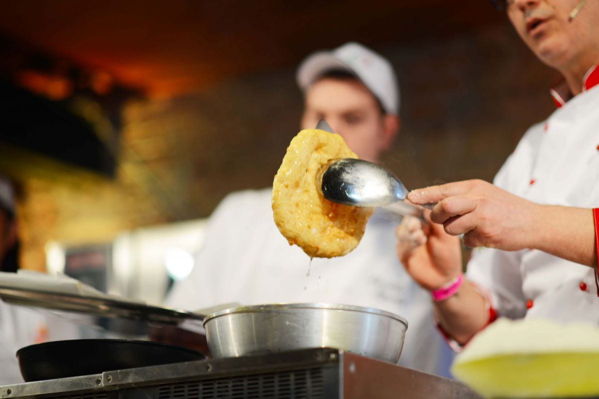 Pizza fritta napoletana. Chef cucina pizza fritta tradizionale. Street food fritto, specialità napoletana.