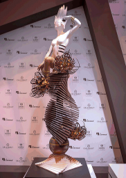 Scultura di cioccolato artistica: figura femminile su spirale decorata. Design e arte culinaria.