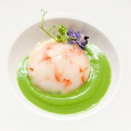 Uovo di Parisi gourmet con crema di piselli e decorazioni floreali. Cucina raffinata.