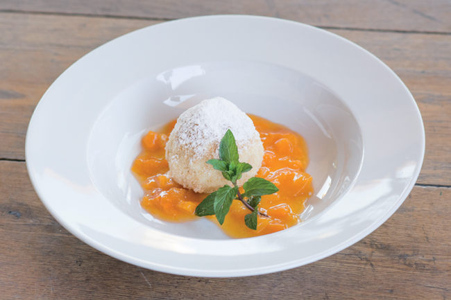 Canederlo dolce all'albicocca con zucchero a velo e menta. Dessert tipico, cucina tradizionale.