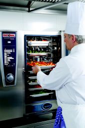 Chef con forno Rational. Verdure fresche in cottura. Cucina professionale.