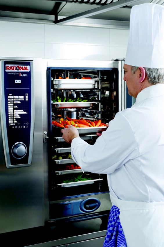 Chef con forno Rational. Verdure fresche in cottura. Cucina professionale.