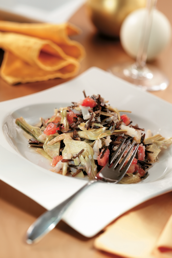 Piatto di riso venere con totani e carciofi. Ricetta gourmet.