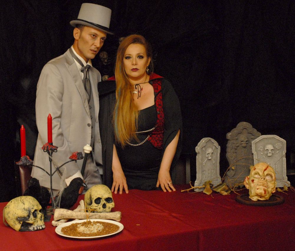 Cosplay Halloween: coppia vestita da vampiri con teschi, candele e lapidi. Festa di Halloween.