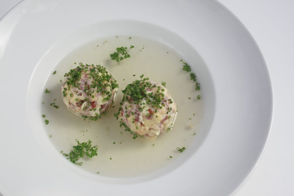 Canederli allo speck in brodo. Piatto tipico trentino con erba cipollina.