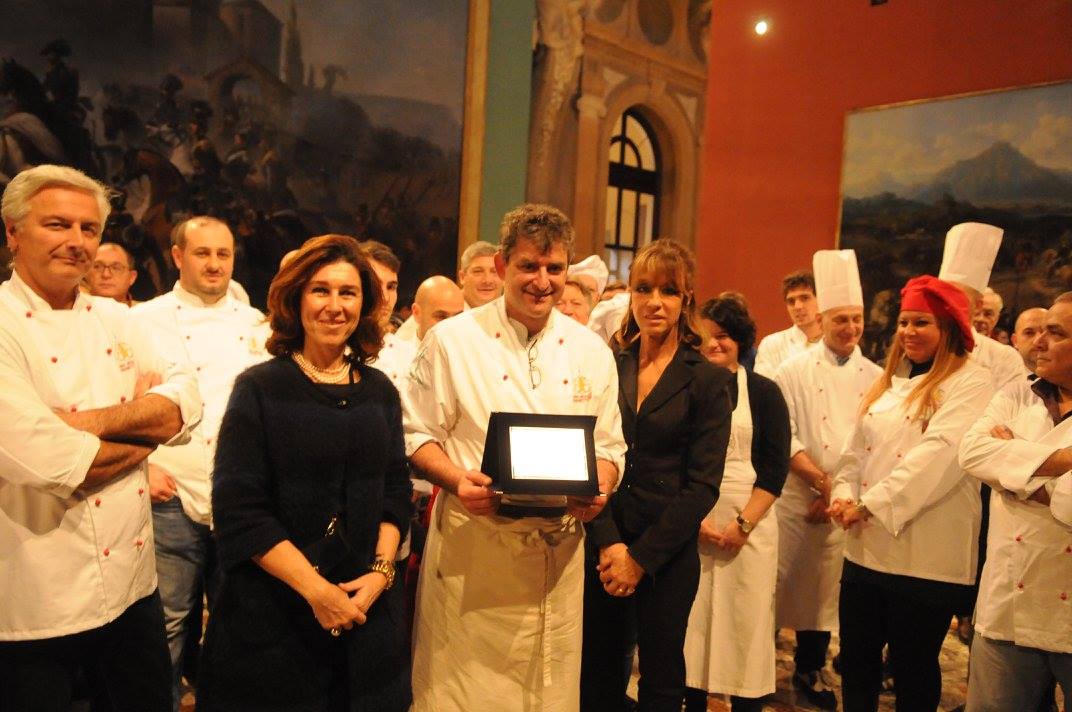 Premiazione chef a Torino. Gruppo di cuochi e personalità. Evento gastronomico, Mole Antonelliana sullo sfondo.