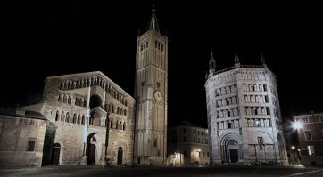 Parma, Piazza Duomo di notte. Cattedrale, Battistero e campanile illuminati. Architettura romanica, Emilia-Romagna.