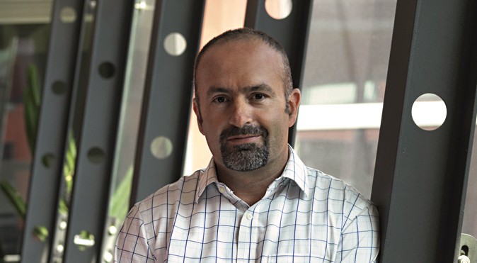 Uomo con barba, camicia a quadri. Ritratto di persona sorridente.