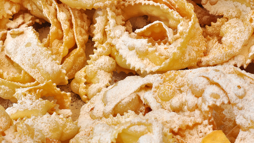 Chiacchiere fritte con zucchero a velo. Dolci tipici di Carnevale.