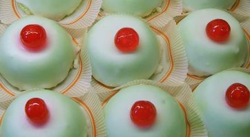 Dolci siciliani Minnuzze di Sant'Agata con glassa verde e ciliegia candita. Pasticceria tradizionale.