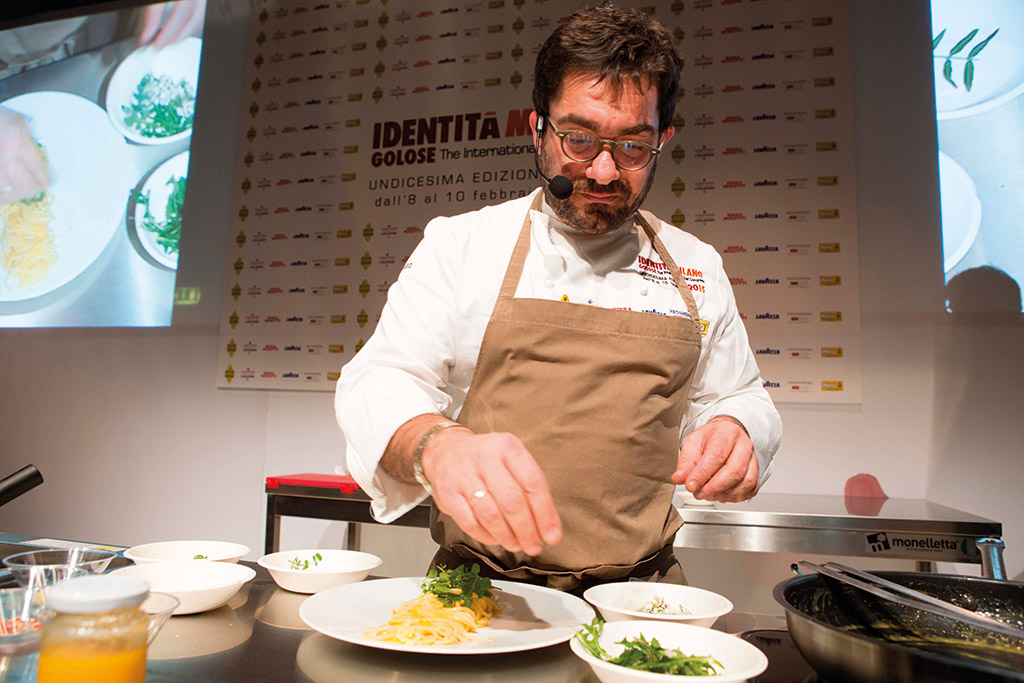 Chef Biagiola ritratto. Cucina italiana, Identità Golose. Chef con pasta e ingredienti freschi. Alta cucina.