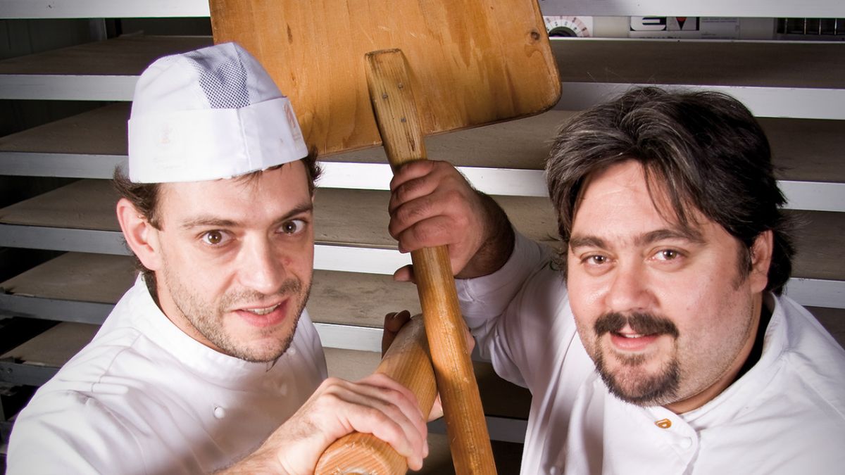 Fratelli panettieri con pala da forno. Artigiani del pane italiano.