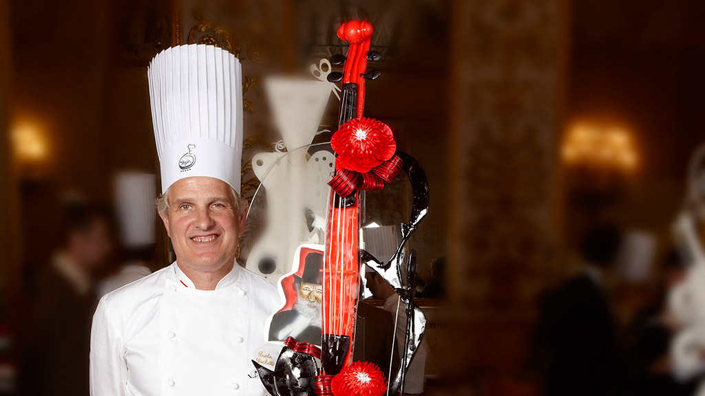 Chef Vincenzo Lonati con scultura di cioccolato a forma di violino. Arte culinaria, pasticceria.