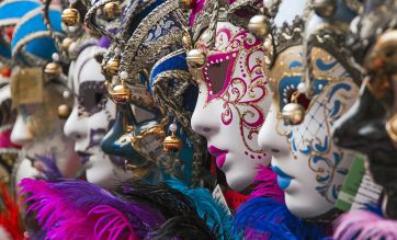 Maschere di Carnevale veneziane colorate con piume e decorazioni dorate. Venezia.