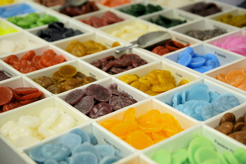 Assortimento colorato di caramelle artigianali in contenitori. Dolciumi misti per vendita al dettaglio.