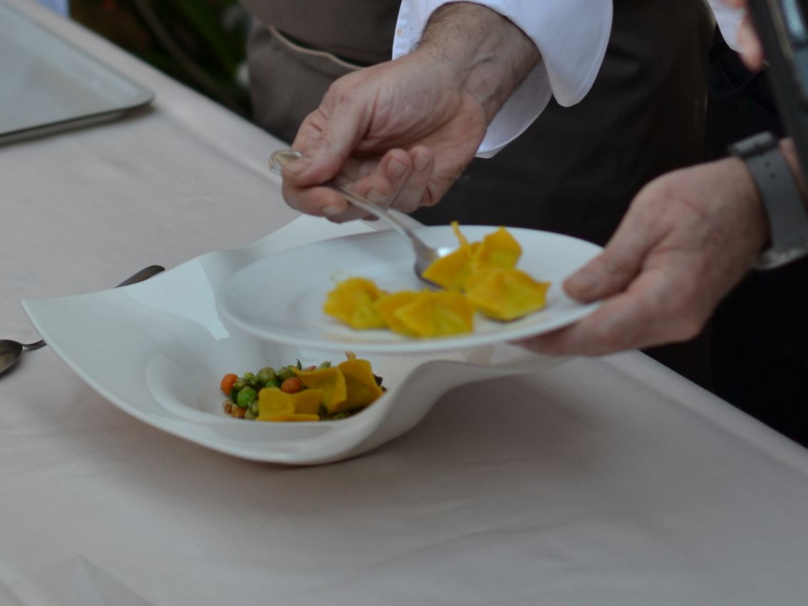 Chef che impiattata tortelli di zucca. Cucina gourmet italiana, pasta fresca fatta a mano.
