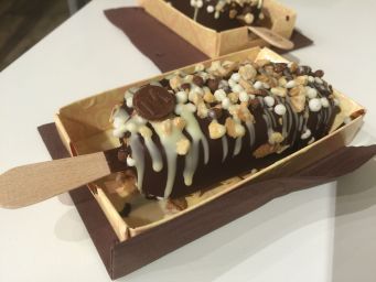 Ghiacciolo artigianale al cioccolato con granella e decorazioni. Dessert goloso su stecco.