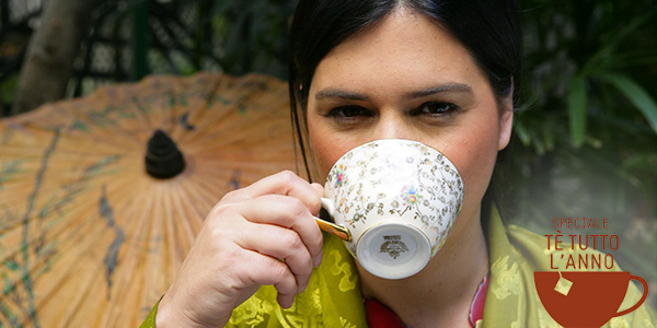 Donna che beve tè in tazza decorata. Relax con tè caldo, bevanda aromatica.