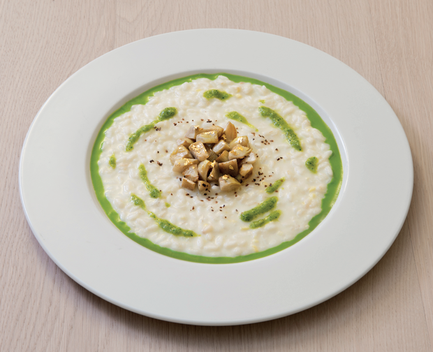 Risotto gourmet con funghi e salsa verde. Piatto elegante, cucina italiana.