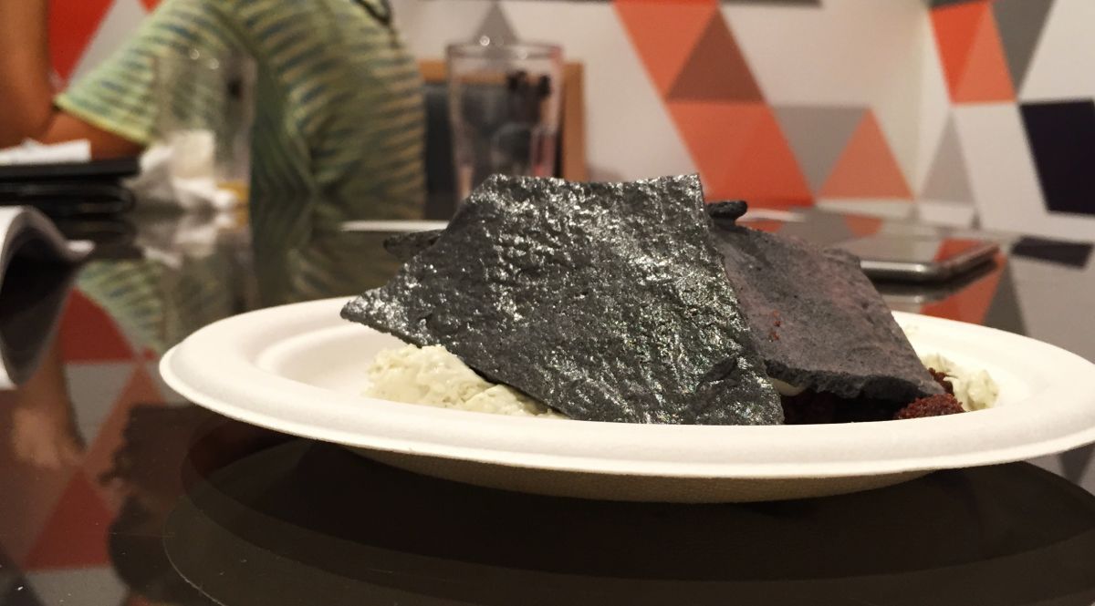 Piatto cemento e terra: dessert innovativo. Scaglie nere, crema chiara, presentazione artistica. Cucina creativa, food design.
