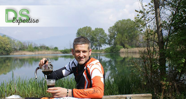 Uomo versa caffè da sifone Bonini. Paesaggio lacustre sullo sfondo. Caffè Bonini, pausa relax.