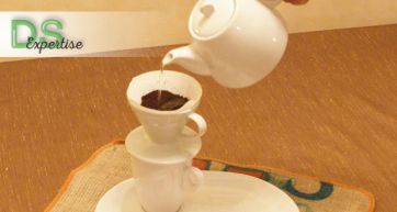 Preparazione caffè filtro. Teiera versa acqua calda su filtro con caffè macinato. Metodo alternativo, aroma intenso.