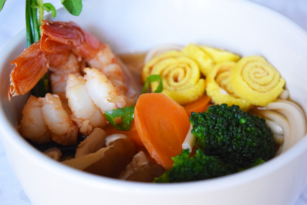 Zuppa di noodles udon con gamberi, carote, broccoli e frittata arrotolata. Cucina asiatica.