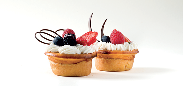 Mini cheesecake New York con frutti di bosco freschi e panna. Deliziosa pasticceria artigianale.