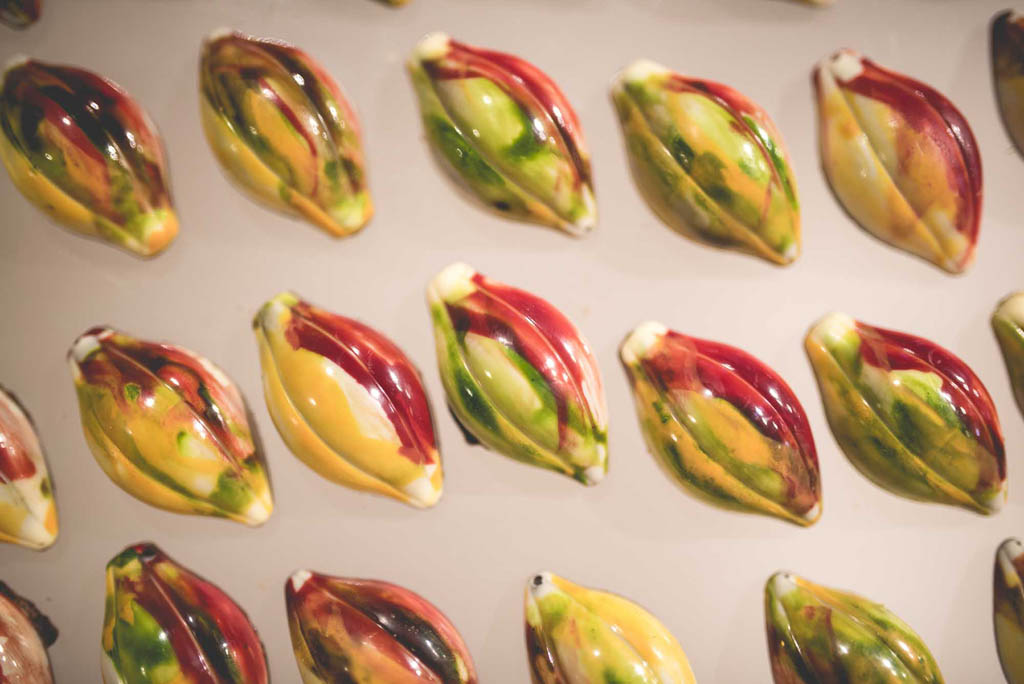 Cioccolatini artigianali a forma di fava di cacao. Dolci colorati, pasticceria creativa.