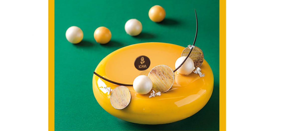 Dolce giallo ICAM con decorazioni sferiche. Pasticceria artigianale, dessert elegante.